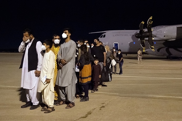 -Un groupe de ressortissants afghans attend sur le tarmac après avoir débarqué d'un premier Airbus A400M de l'armée de l'air espagnole. Photo Belen Diaz / AFP via Getty Images.