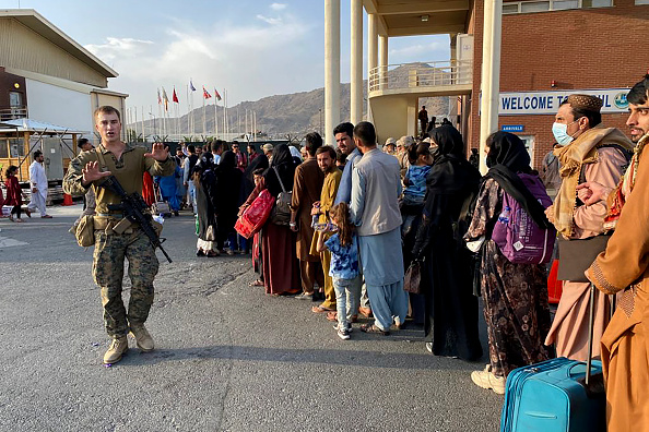 Des Afghans font la queue pour embarquer dans un avion militaire américain afin de quitter l'Afghanistan, à l'aéroport militaire de Kaboul. (Photo : SHAKIB RAHMANI/AFP via Getty Images)