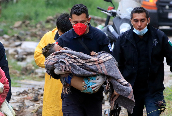 -Un ambulancier paramédical de la sécurité publique transporte un enfant après un glissement de terrain sur une colline en raison du passage de l'ouragan Grace, Mexique, le 21 août 2021. Photo EDUARDO MURILLO/AFP via Getty Images.
