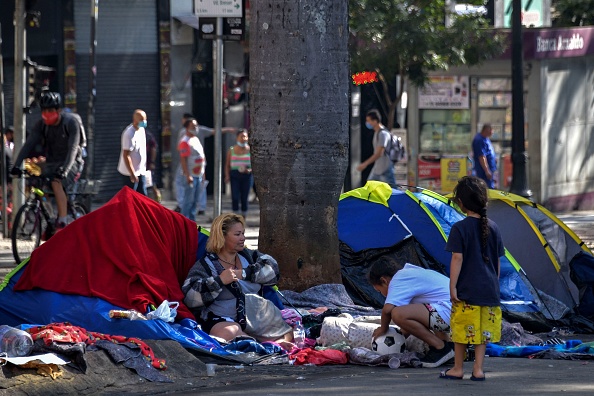 -Une famille sans-abri est vue sur la place Se, dans le centre-ville de Sao Paulo, au Brésil, le 19 août 2021. Photo de NELSON ALMEIDA / AFP via Getty Images.