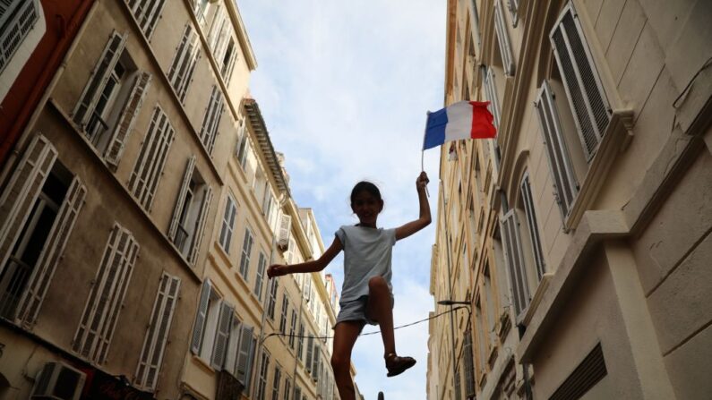 Un enfant brandit un drapeau français lors d'une manifestation nationale contre le passe sanitaire le 7 août 2021 à Marseille. (Roger Anis/Getty Images)
