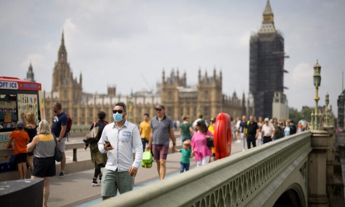 Des piétons traversent le pont de Westminster dans le centre de Londres, le 26 juillet 2021. (Tolga Akmen / AFP via Getty Images)