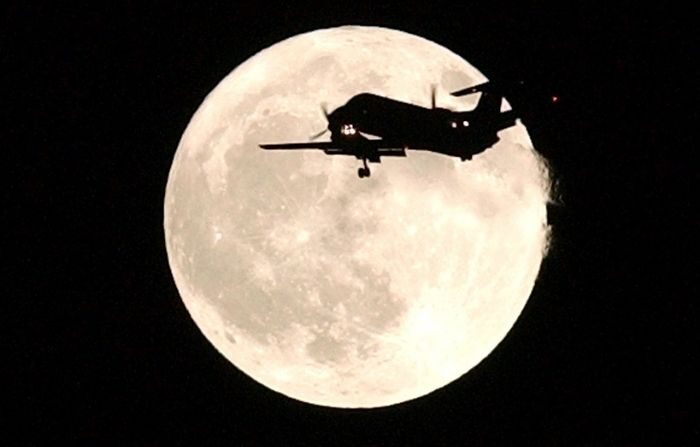 Un avion passe devant une pleine lune alors qu'il approche de l'aéroport international de San Francisco, le 31 octobre 2001, au-dessus de Foster City, en Californie. La pleine lune, qui est une lune bleue, est la première à se produire le soir d'Halloween depuis 46 ans. (Justin Sullivan/Getty Images) 