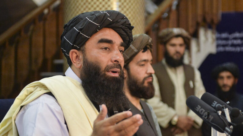 Le porte-parole des talibans, Zabihullah Mujahid (à gauche), fait des gestes pendant qu'il parle lors de la première conférence de presse à Kaboul, le 17 août 2021, après la prise de contrôle de l'Afghanistan par les talibans. (Hoshang Hashimi/AFP via Getty Images) 