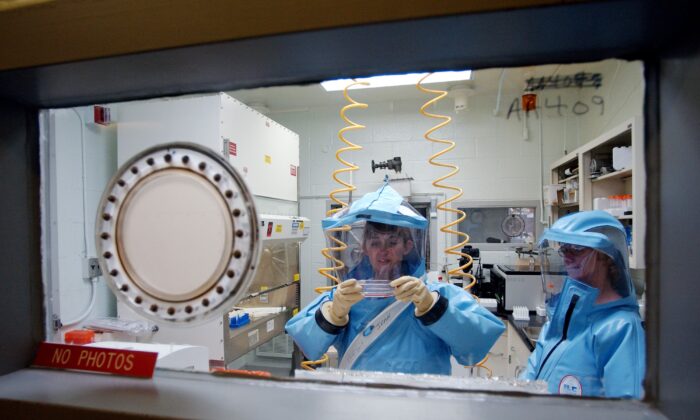 Des membres du personnel travaillent à l'intérieur du laboratoire de recherche de niveau 4 de l'Institut de recherche médicale sur les maladies infectieuses de l'armée américaine à Fort Detrick, le 26 septembre 2002. (Olivier Douliery/AFP via Getty Images)