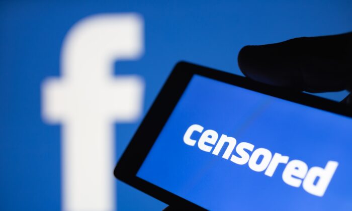 Un smartphone en main affichant le mot "censuré" en anglais devant un logo de Facebook. (klevo/Shutterstock)