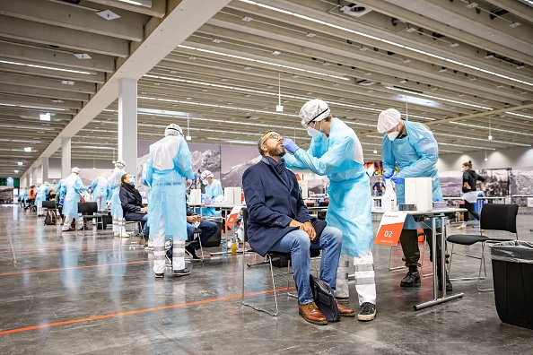 Des agents de santé effectuent des prélèvements sur des personnes au parc des expositions d'Innsbruck, en Autriche, alors que le dépistage de masse du coronavirus a débuté dans les États du Vorarlberg et du Tyrol ainsi que dans la capitale Vienne, le 4 décembre 2020. (Photo : JOHANN GRODER/EXPA/AFP via Getty Images)