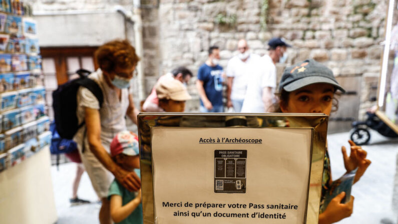 Des touristes passent devant l'entrée de l'Archéoscope, salle de spectacle du Mont-Saint-Michel, le 22 juillet 2021. (Crédit photo SAMEER AL-DOUMY/AFP via Getty Images)