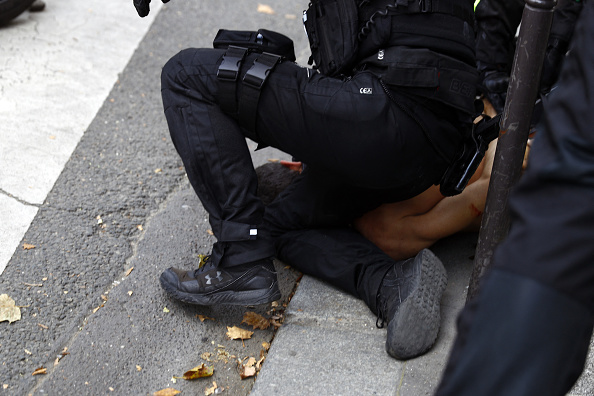 Des policiers arrêtent un homme  (SAMEER AL-DOUMY/AFP via Getty Images)