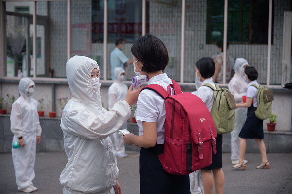 -Des étudiants de l'Université de commerce de Pyongyang Jang subissent des contrôles de température avant d'entrer sur le campus, à Pyongyang le 11 août 2021. Photo de KIM Won Jin / AFP via Getty Images.