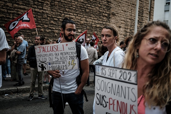 Des infirmières tiennent des pancartes alors qu'elles manifestent devant l'A.R.S. (Agence régionale de santé) à Lyon, dans le sud-est de la France, le 14 septembre 2021, contre l'obligation du passeport sanitaire pour les travailleurs hospitaliers. (JEFF PACHOUD/AFP via Getty Images)