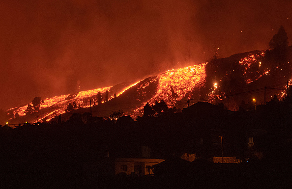 Des coulées de lave s'approchent des maisons, le mont Cumbre Vieja est entré en éruption à El Paso, crachant des colonnes de fumée, de cendres et de lave sur l'île canarienne de La Palma, le 19 septembre 2021. Photo de DESIREE MARTIN / AFP via Getty Images.