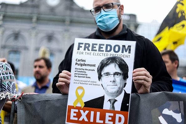 -Un manifestant tient un dépliant représentant l'ancien président catalan Carles Puigdemont lors d'une manifestation près du Parlement européen à Bruxelles, le 24 septembre 2021 après l'arrestation de l'homme politique en exil en Italie. Photo de Kenzo TRIBOUILLARD / AFP via Getty Images.