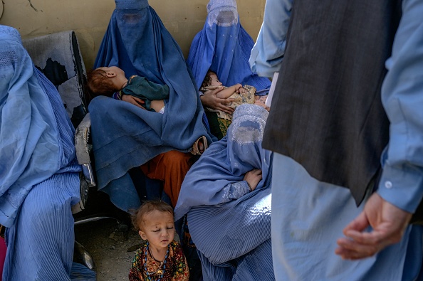 Des femmes portant une burqa sont assises avec leurs enfants dans la ville frontalière de Spin Boldak, le 25 septembre 2021.  (Photo : BULENT KILIC/AFP via Getty Images)