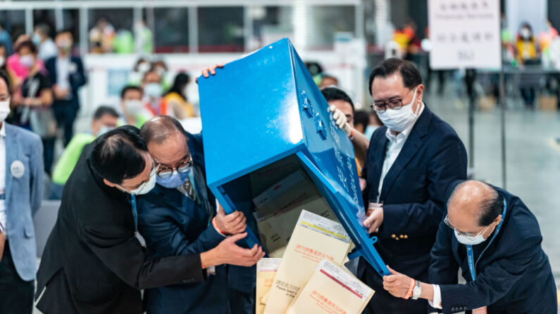 Des fonctionnaires ouvrent une urne alors que le décompte des voix commence au Convention Centre, lors des élections ordinaires du sous-secteur 2021 du Comité électoral, le 19 septembre 2021 à Hong Kong, en Chine. (Photo : Anthony Kwan/Getty Images)