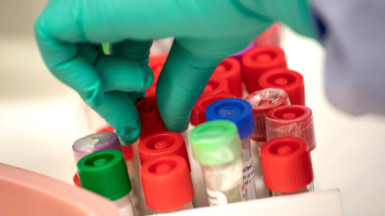 Un médecin effectue des tests dans un laboratoire médicale sur des flacons d'échantillons pour dépister le virus du PCC au laboratoire de virologie de l'Université de médecine de Washington, à Seattle (Wash.), le 13 mars 2020. (John Moore/Getty Images)