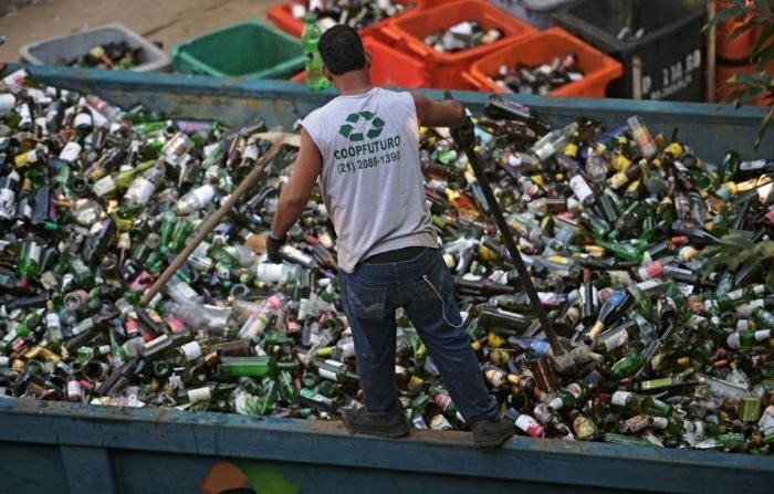 Un ouvrier écrase des bouteilles en verre à CoopFuturo, un collectif de tri qui reçoit des ordures du service de collecte du gouvernement local et vend ensuite les matériaux à des entreprises de recyclage spécialisées, à Rio de Janeiro, au Brésil, le 21 mai 2019. (CARL DE SOUZA/AFP via Getty Images)