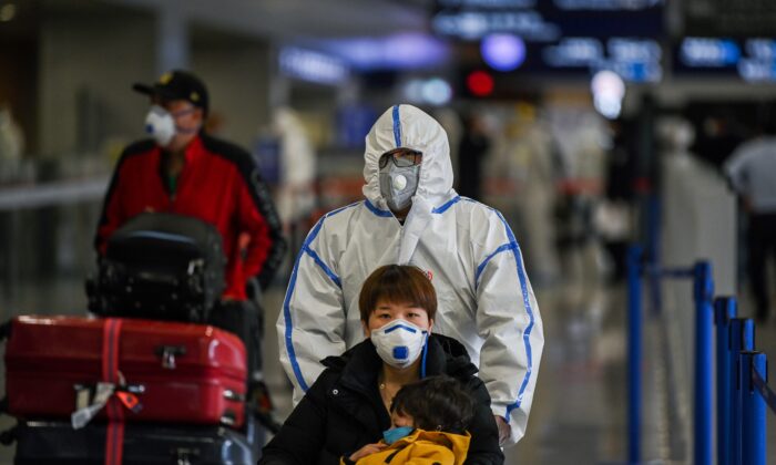 Des passagers portant des masques arrivent à l'aéroport international de Shanghai Pudong, à Shanghai, le 19 mars 2020. (Hector Retamal/AFP via Getty Images)