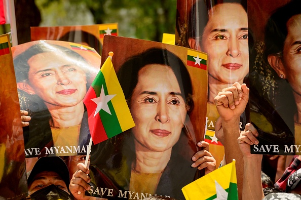 -Des migrants birmans en Thaïlande brandissent des photos de la dirigeante civile birmane détenue Aung San Suu Kyi à Bangkok le 7 mars 2021. Photo de Mladen ANTONOV / AFP via Getty Images.