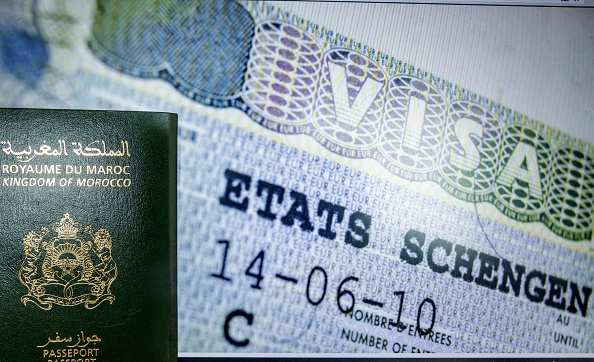 Une photo prise le 28 septembre 2021 dans la capitale marocaine Rabat montre un passeport marocain adossé à un visa Schengen. (FADEL SENNA/AFP via Getty Images)