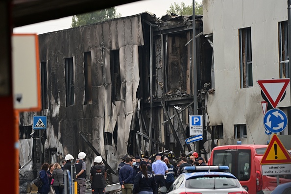 La police et les équipes de secours  devant un immeuble de bureaux où un petit avion transportant cinq passagers et le pilote s'est écrasé dans la banlieue de Milan. (Photo : MIGUEL MEDINA/AFP via Getty Images)