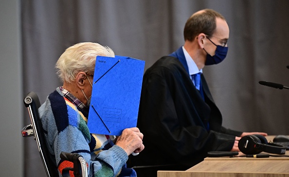 -L'accusé Josef S est assis à côté de son avocat Stefan Waterkamp et cache son visage derrière un dossier en attendant le début de son procès à Brandenburg  dans le nord-est de l'Allemagne, le 7 octobre 2021. Photo de Tobias Schwarz / AFP via Getty Images.