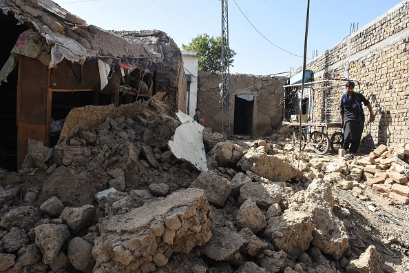 -Un habitant enlève un chariot à côté des décombres de maisons effondrées à la suite d'un tremblement de terre dans le district montagneux reculé de Harnai le 7 octobre 2021. Photo Banaras KHAN / AFP via Getty Images.