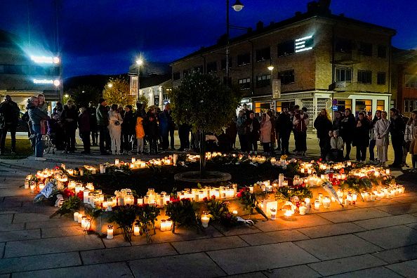 -Des gens déposent des fleurs et allument des bougies sur le Stortorvet à Kongsberg pour honorer les morts, le 14 octobre 2021, le lendemain du jour où un homme armé d'un arc et de flèches a tué 5 personnes. Photo de Terje Bendiksby / NTB / AFP via Getty Images.