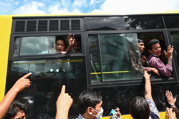 Les détenus libérés de la prison d'Insein célèbrent avec la foule leur libération depuis un bus à Yangon le 19 octobre 2021. Photo par STR/AFP via Getty Images.