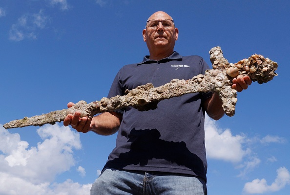 Jacob Sharvit, de l'Autorité israélienne des antiquités, montre une épée ancienne d'un mètre de long qui, selon les experts, remonte à l'époque des croisades et aurait appartenu à un chevalier. (Photo : JACK GUEZ/AFP via Getty Images)