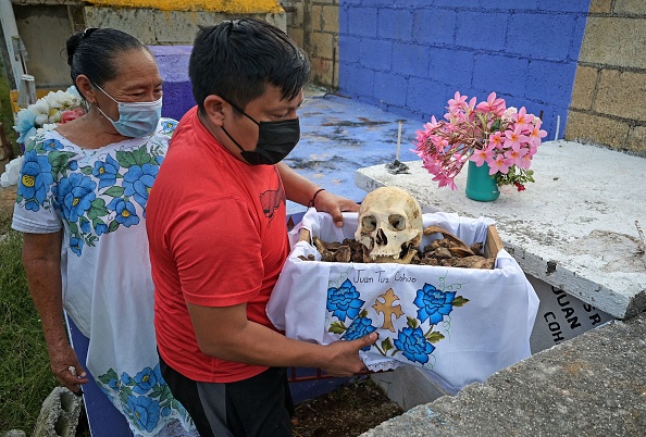 -Des résidents de la communauté maya de Pomuch nettoient le crâne d'un parent lors d'un rituel privé précédant les célébrations du Jour des Morts, le 19 octobre 2021, au Mexique. Photo de LUIS PEREZ / AFP via Getty Images.