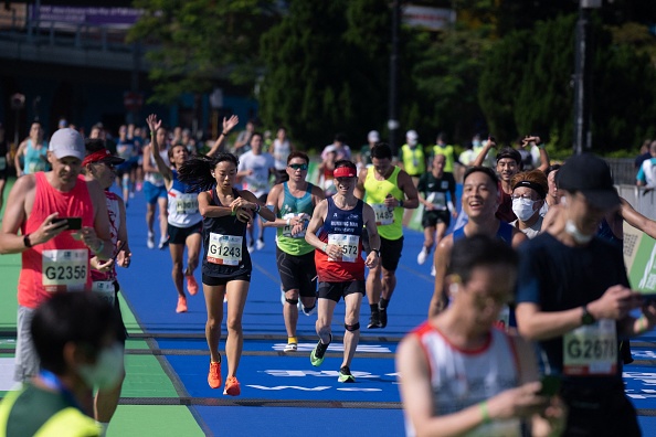 -Les coureurs franchissent la ligne d'arrivée du marathon annuel de Hong le 24 octobre 2021. Photo de Bertha WANG / AFP via Getty Images.