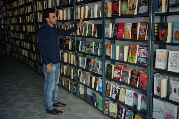 -Mustafa Barak, étudiant en droit et client de Saadat Books, un magasin spécialisé dans les textes en anglais, regarde un livre à Kaboul le 23 octobre 2021. Photo Hoshang Hashimi / AFP via Getty Images.