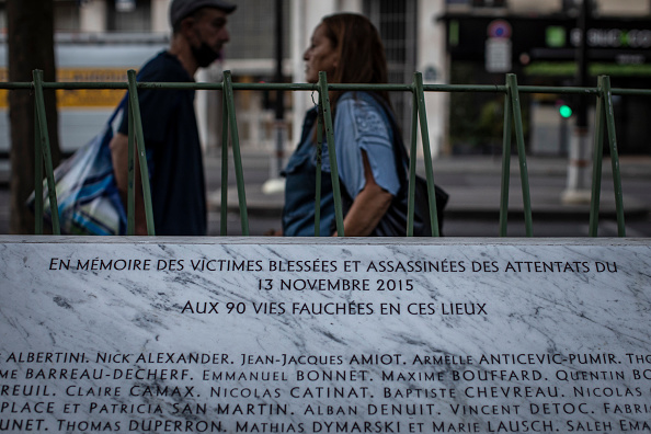 Des piétons marchent près de la plaque commémorative pour les victimes des attaques terroristes de novembre 2015 près du théâtre et du café Bataclan, le 7 septembre 2021 à Paris, France.  (Siegfried Modola/Getty Images)