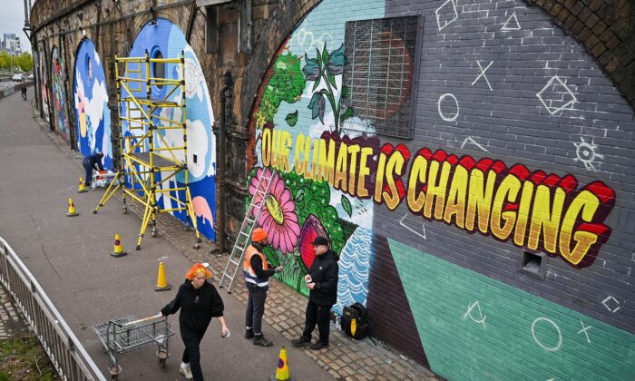 Des artistes peignent sur un mur près du Scottish Event Campus à Glasgow, en Écosse, le 13 octobre 2021 – l’endroit où se tiendra la 26e Conférence des Nations unies sur le changement climatique du 31 octobre au 12 novembre. (Jeff J. Mitchell/Getty Images)

