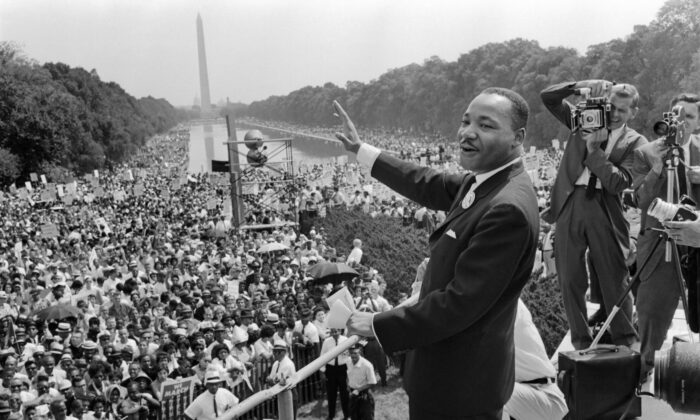 Le leader des droits civiques Martin Luther King Jr. salue ses supporters sur le Mall à Washington, le 28 août 1963. (-/AFP via Getty Images)