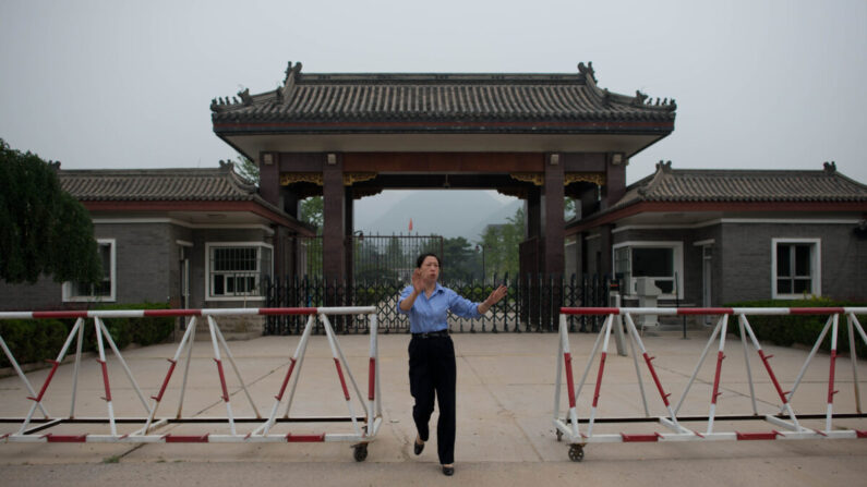 Une policière s'approche pour empêcher la prise de photos à l'entrée de la prison de Qincheng, dans la banlieue de Pékin, le 12 septembre 2013. (Ed Jones/AFP via Getty Images)