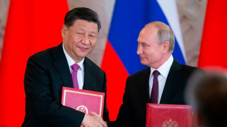 Le président russe Vladimir Poutine et son homologue chinois Xi Jinping échangent des documents lors de la cérémonie de signature organisée à la suite de leurs entretiens au Kremlin à Moscou, le 5 juin 2019. (Alexander Zemlianichenko/AFP/Getty Images)