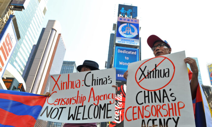 Des étudiants pour un Tibet libre protestent sous un nouveau panneau d'affichage électronique loué par Xinhua (2e en partant du haut), l'agence de presse du régime chinois, au moment de son lancement à Times Square, à New York, le 1er août 2011. (Stan Honda/AFP via Getty Images)