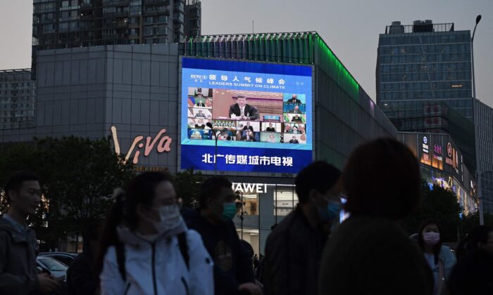 Un programme d'information présente l'apparition du dirigeant du PCC, Xi Jinping, lors d'un sommet sur le climat organisé par les États-Unis, sur un écran géant à Pékin, le 23 avril 2021. (Greg Baker/AFP via Getty Images)