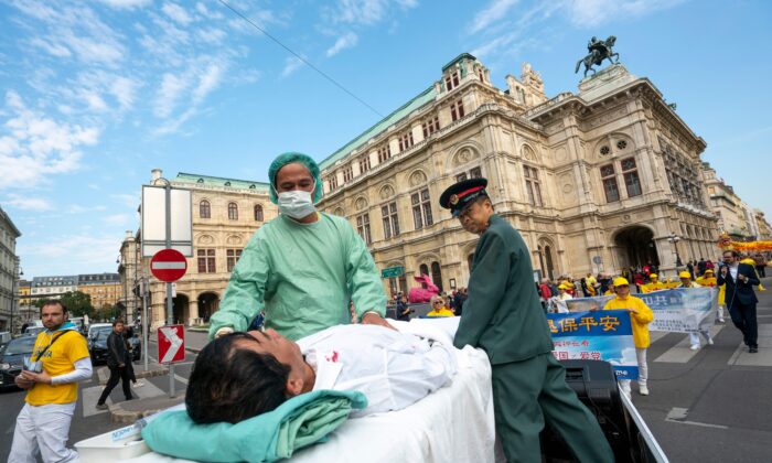 Des pratiquants de Falun Gong à Vienne, en Autriche, mettent en scène une opération de prélèvement d'organes  lors d'une manifestation contre les prélèvements forcés en Chine.  1er octobre 2018. (JOE KLAMAR/AFP via Getty Images)