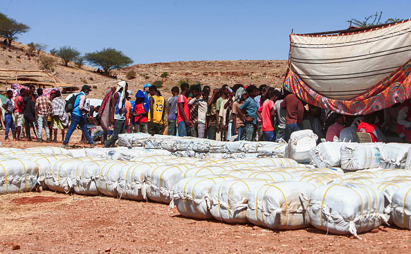 -Des réfugiés éthiopiens ont fui les combats dans la province du Tigré ils font la queue pour recevoir des fournitures et de la nourriture au camp, dans l'État soudanais, le 16 novembre 2020. Photo par Ebrahim HAMID / AFP via Getty Images.