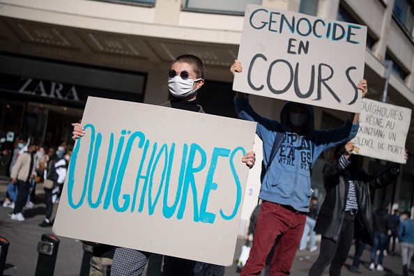 Des manifestants tiennent des banderoles de soutien aux minorités ouïghoures devant un magasin Zara, dans l'ouest de la France, le 19 mars 2021.  (LOIC VENANCE/AFP via Getty Images)