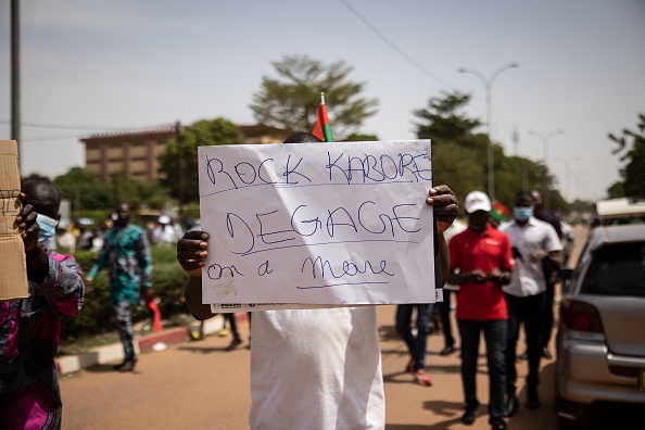 -Un manifestant tient une pancarte lors d'une marche de l'opposition pour protester contre l'aggravation de la situation sécuritaire et demander une réponse aux attaques djihadistes, à Ouagadougou, 2021. Photo OLYMPIA DE MAISMON/AFP via Getty Images.