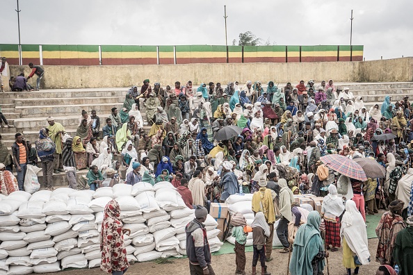 -Les personnes qui ont fui la guerre se rassemblent dans un camp de déplacés internes, temporairement construit pour recevoir leurs premiers sacs de blé du Programme alimentaire mondial (PAM) à Debark, Éthiopie, le 15 septembre 2021. Photo d'Amanuel Sileshi / AFP via Getty Images.