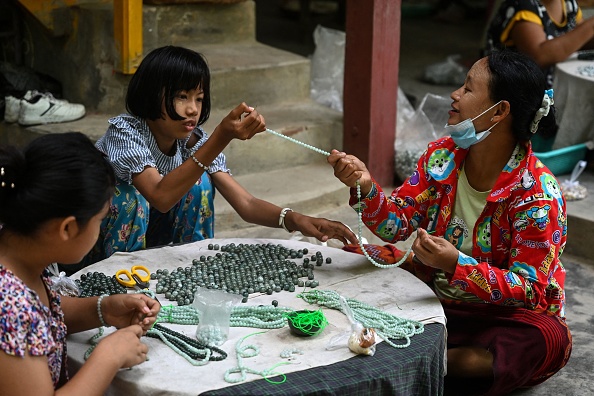 - Des femmes travaillent dans un atelier de jade dans la région de Sagaing au Myanmar. Photo by STR/AFP via Getty Images. 
