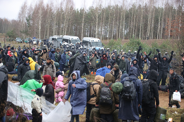 Des migrants à la frontière biélorusse-polonaise dans la région de Grodno. Le 8 novembre, la Pologne a déclaré que des centaines de migrants du Bélarus descendaient à sa frontière dans le but de pénétrer de force dans le pays. (Photo : LEONID SHCHEGLOV/BELTA/AFP via Getty Images)