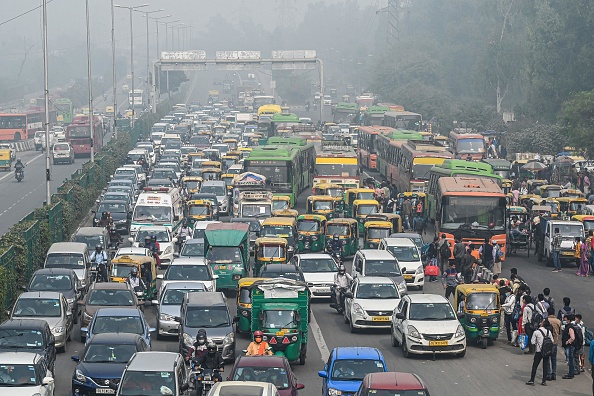 Des bus essaient de se frayer un chemin le long d'une route très fréquentée dans des conditions de smog intense à New Delhi le 12 novembre 2021. Photo de Prakash SINGH / AFP via Getty Images.