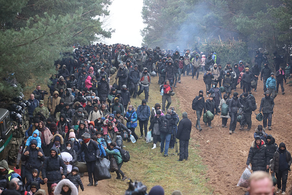 Des migrants se dirigent vers le poste-frontière polonais de Kuznica, à la frontière biélorusse-polonaise, le 15 novembre 2021. (Photo : LEONID SHCHEGLOV/BELTA/AFP via Getty Images)