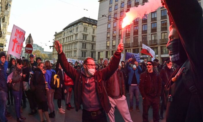 Des manifestants allument des fusées de détresse lors d'un rassemblement organisé par le Parti de la liberté d'Autriche contre les décrets relatifs au Covid-19 à Vienne, en Autriche, le 20 novembre 2021. (Joe Klamar/AFP via Getty Images)